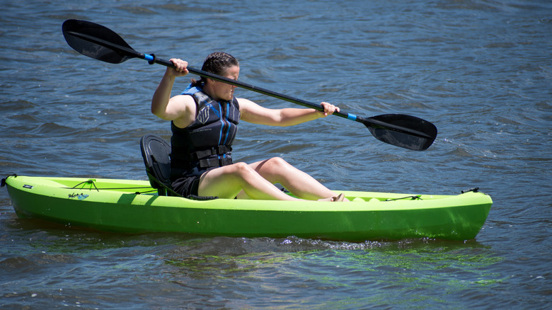 person paddles a kayak