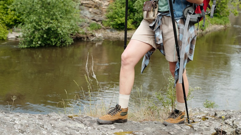 waist-down image of person hiking in shorts with trekking poles
