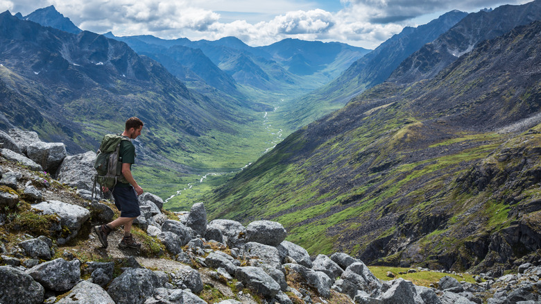 guy wearing backpack and shorts hiking in mountains