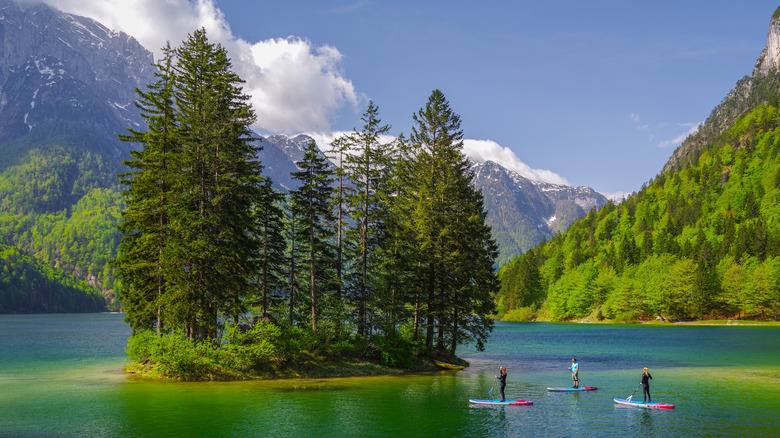 Paddleboarding around the small island in Lago del Predil in the Julian Alps of Friuli-Venezia Giulia, Italy