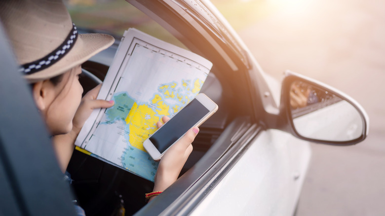 Woman looking at map and phone
