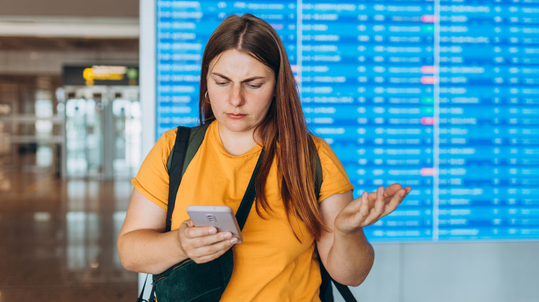Woman confused at departure board