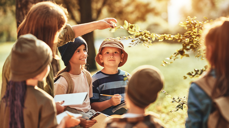 instructor and group of kids studying plant life