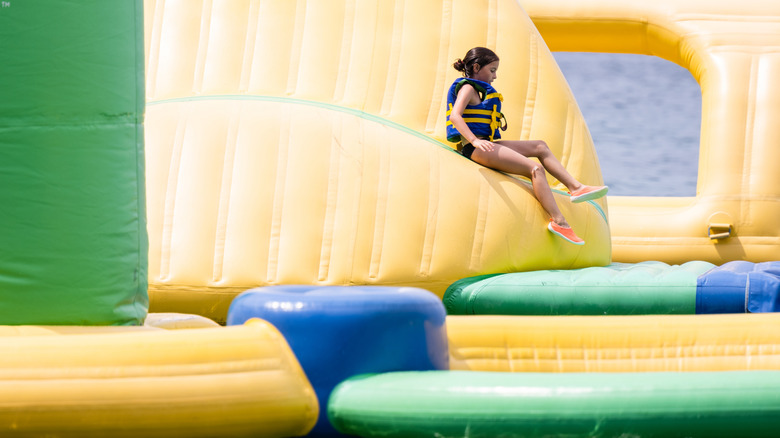 Girl in life vest on inflatable water park