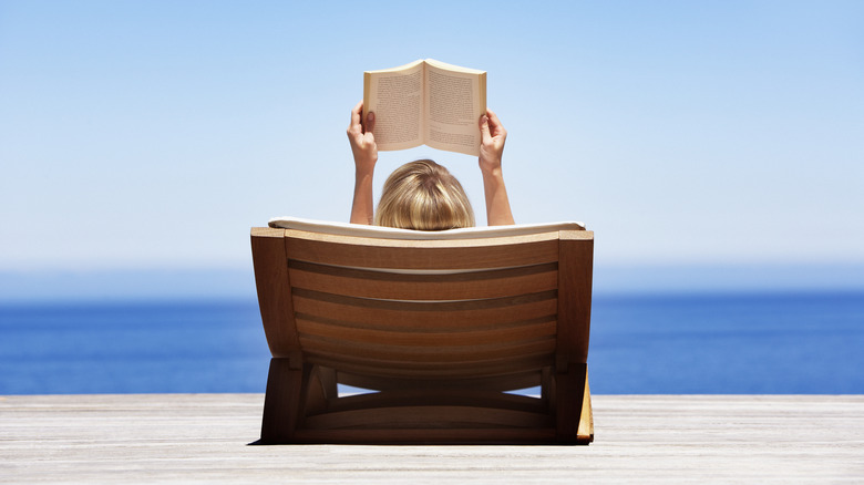 Woman reading by ocean