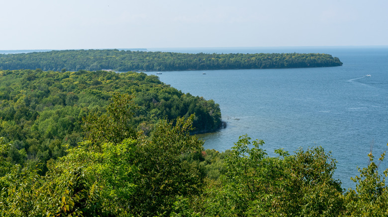 A wide shot of tree-ccovered Peninsula State Park reaching into blue Lake Michigan
