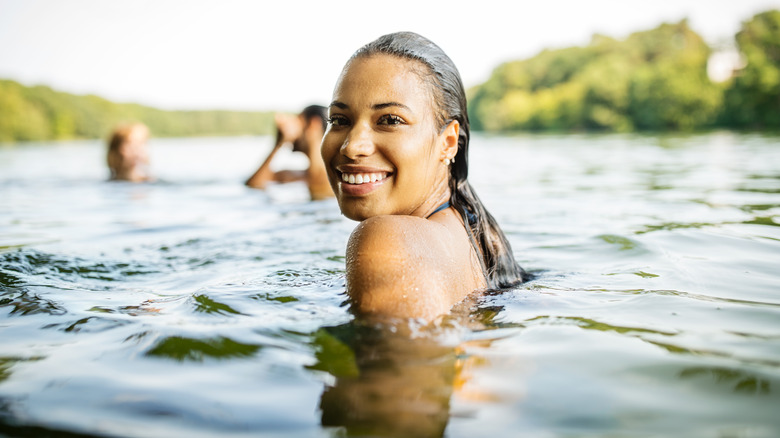 A swimmer looks back into the camera and smiles
