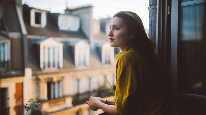 woman looking out Paris window