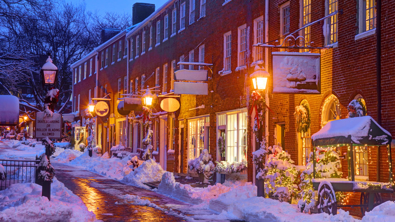 A snow-covered street with lights glowing in the fading light in Newburyport