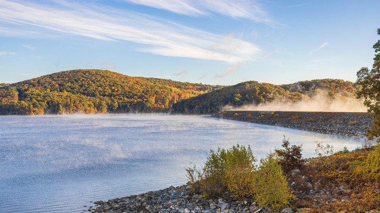 mist rising from a reservoir with hills in the background