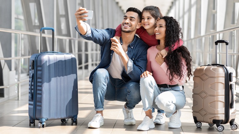 family posing for photo at airport