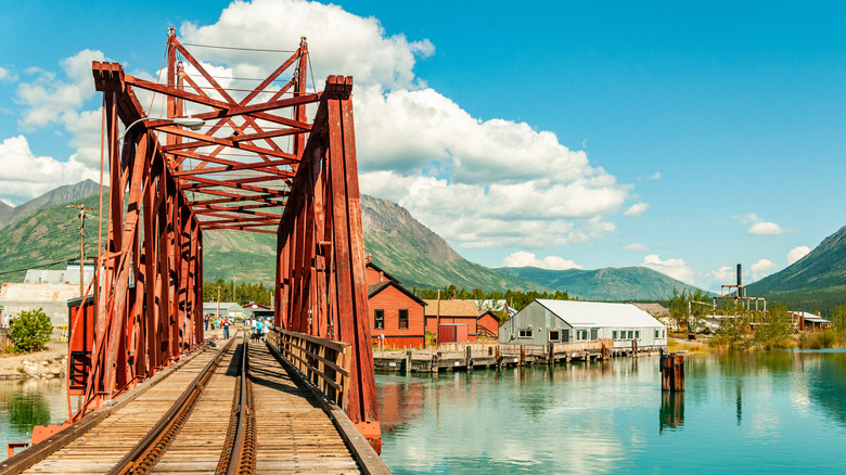 The town of Carcross can be seen from a railroad track crossing a lake