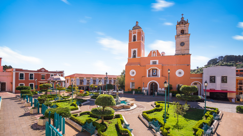 Colorful buildings and church around the central square in Real del Monte