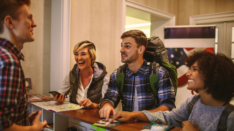 travelers talking to hostel receptionist