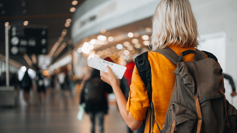 Airport traveler holding boarding pass