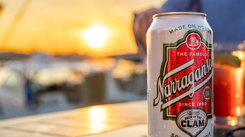 A can of Narragansett beer stands in front of a setting sun
