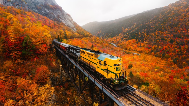 The Conway Scenic Railroad train chugs through an autumnal valley in New Hampshire