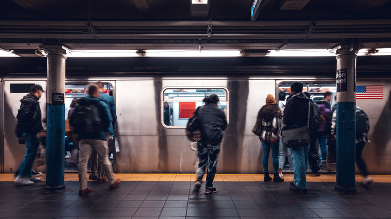 People boarding the train at an underground NY subway station.
