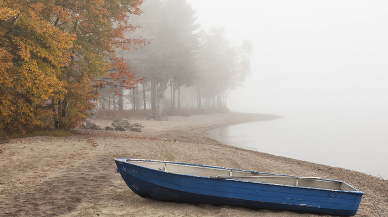 A rowboat waits on the misty shore of Schroon Lake in fall