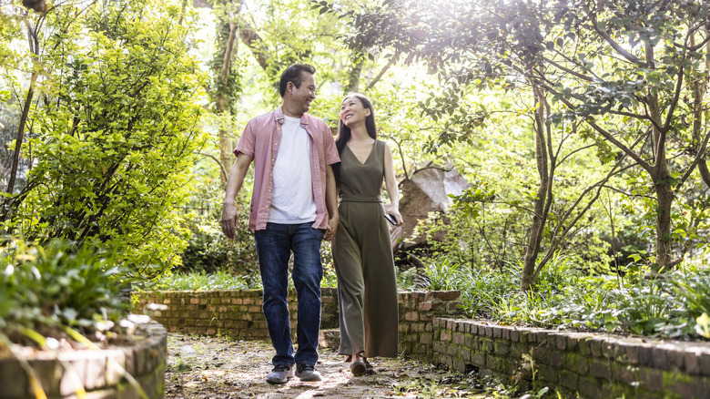 Middle-aged couple walking through beautiful botanical garden