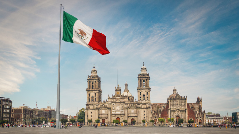 The Zócalo, an example of Mexico City architecture, behind a Mexican flag.