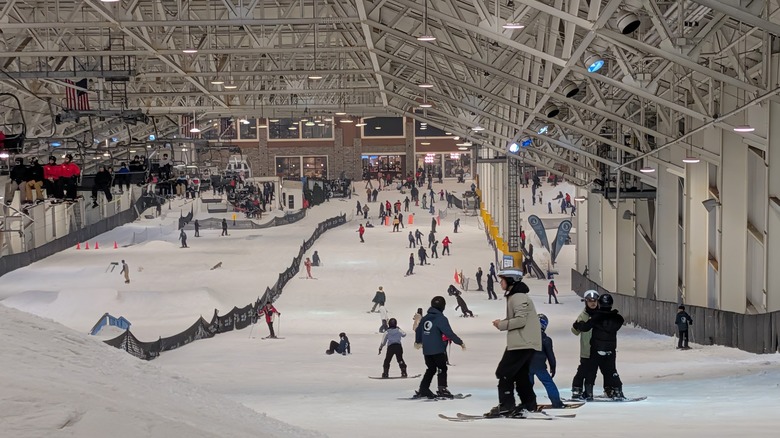 Big Snow indoor ski park with skiers on a snowy run and a chairlift.
