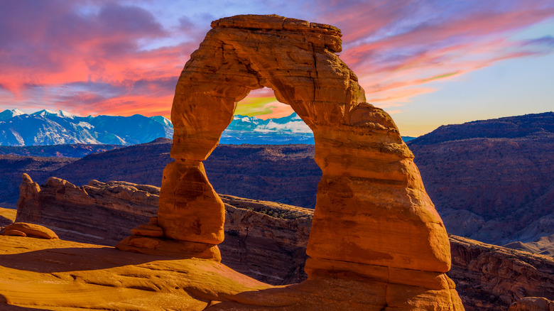 Delicate Arch with snowy mountains in the background at Arches National Park in Utah