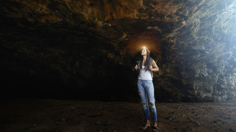A woman in a cave looking up