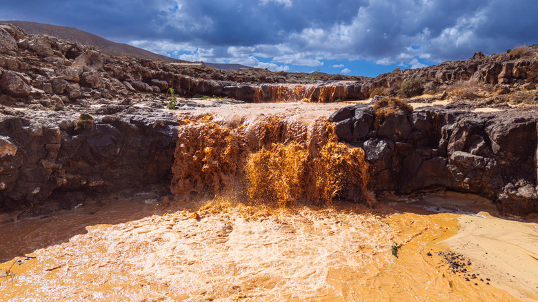 Water pours over a rocky desert shelf