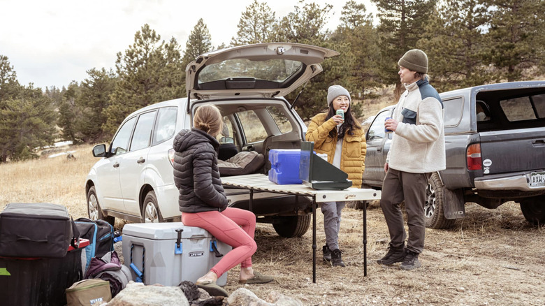 Campers sit around the Hele Box camping platform turned into a camp table