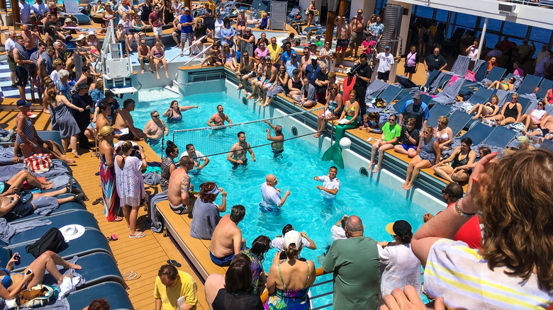 People play volleyball in a crowded cruise ship pool