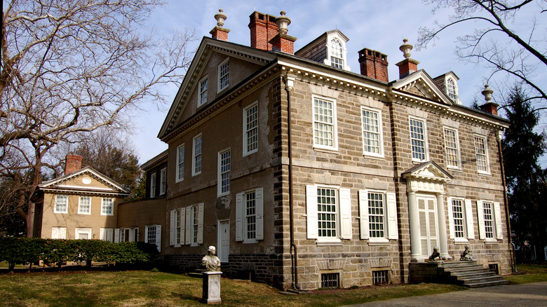 a large stone built house with white shuttered windows