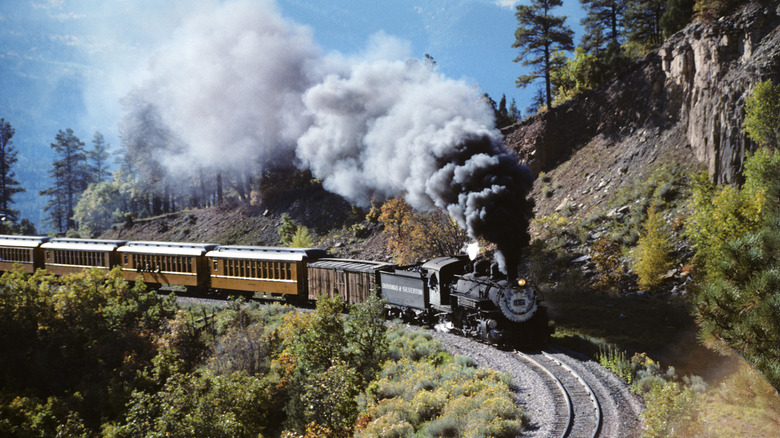 Steam train going around mountain bend