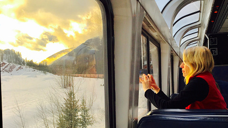 An Amtrak passenger taking photos of scenery.