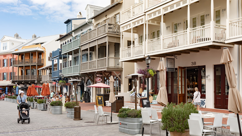 Street with outdoor cafe seating and buildings with large balconies
