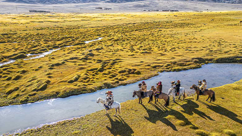 a group of eagle hunters traveling across the steppe in Mongolia