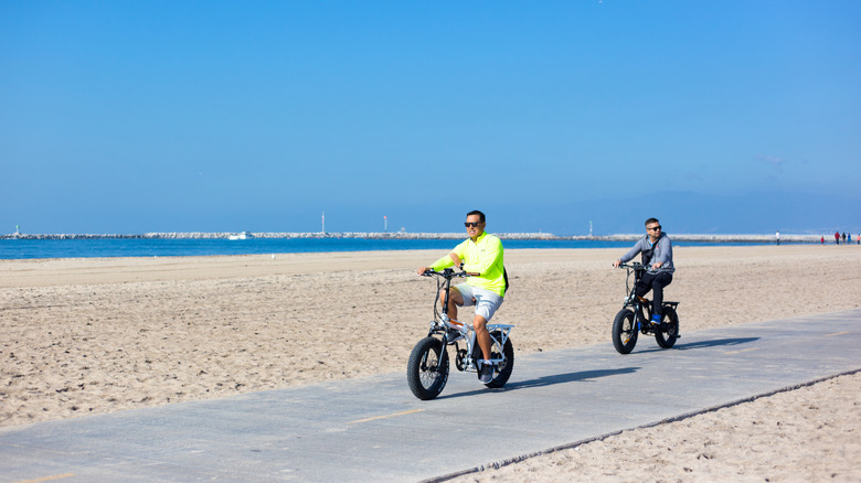 Two people riding bikes at Playa del Rey Beach