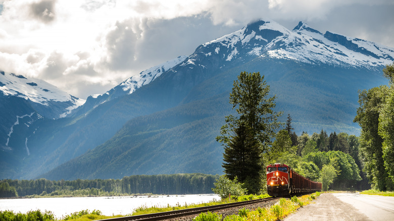 Train travels alongside the Skeena River on Highway 16 between Prince George and Prince Rupert with mountain in background