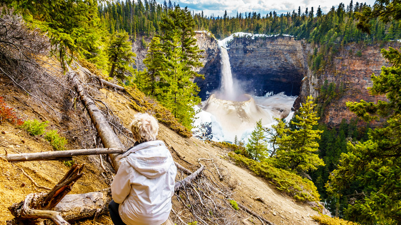 Woman looking at a frozen Helmcken Falls in the winter