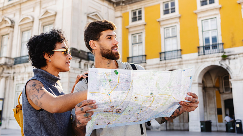Two tourists holding map while sightseeing in Europe