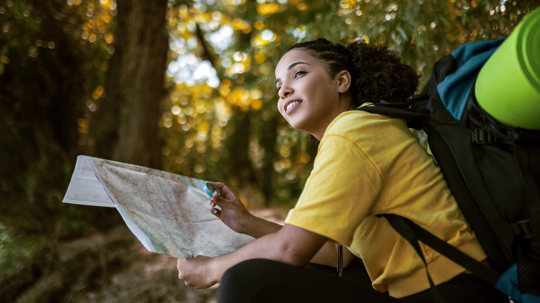 woman using a map on a hiking trail