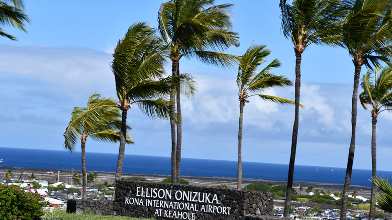 The KOA airport sign with palm trees.