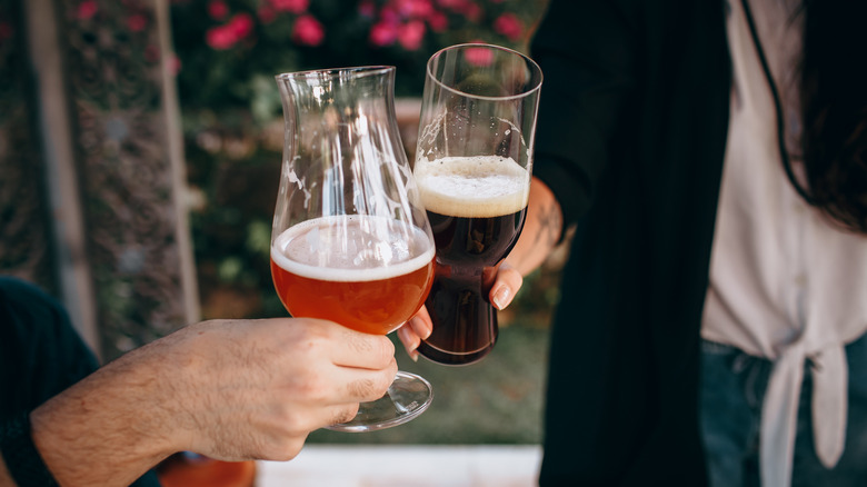 Two people toasting with beer glasses