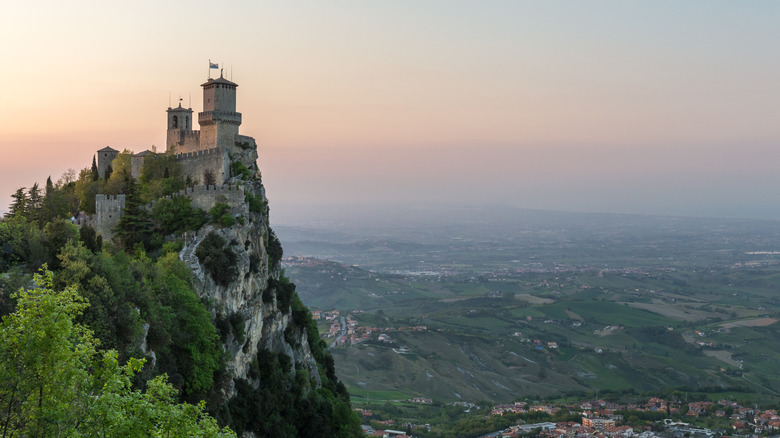 A scenic photo of a castle on a cliff at sunset