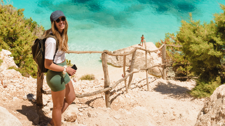 young woman hiking down to a secluded beach