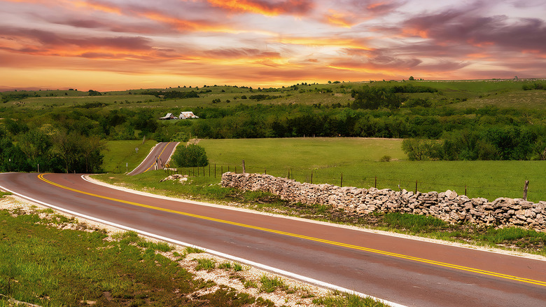 sunset over road in hilly area