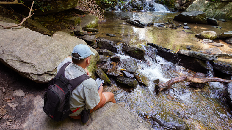 Man relaxing on hiking trip at Catawba Falls near Old Fort, Blue Ridge Mountains, North Carolina.
