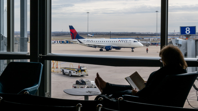 A woman sits reading in the departure lounge of Austin-Bergstrom International Airport.