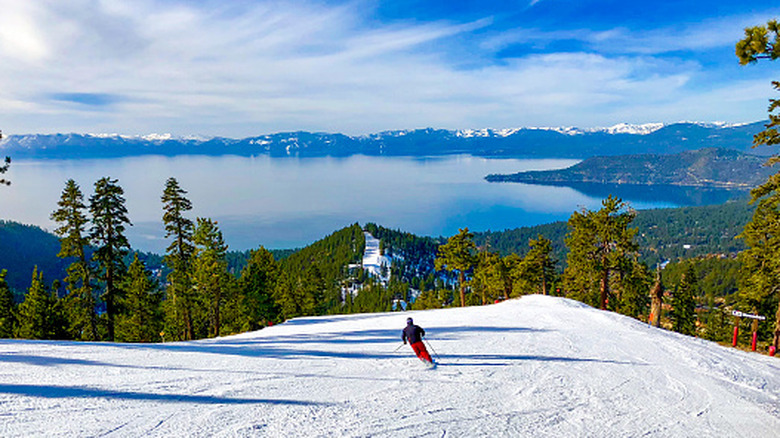 Someone downhill skiing with Lake Tahoe in the background.