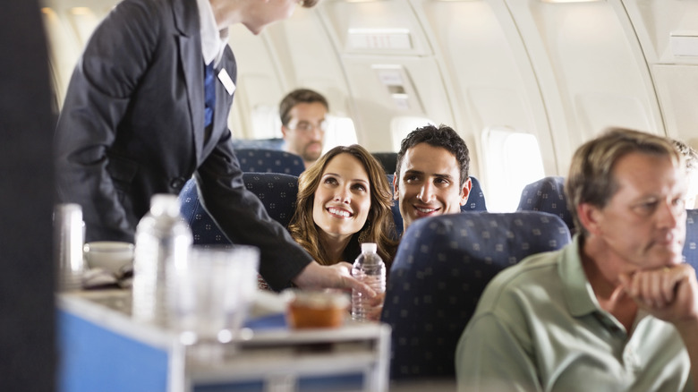 Flight attendant serving passengers